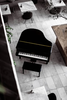 black grand piano on brown wooden floor