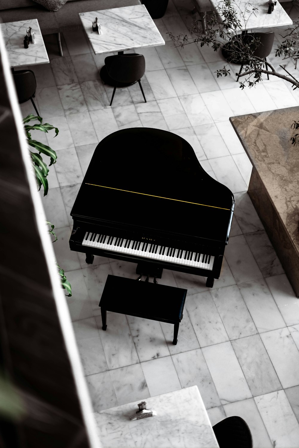 茶色の木製の床に黒いグランドピアノ