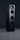 A sleek black audio speaker with a modern, minimalist design. The speaker consists of two stacked rectangular units, each featuring circular sound outputs. The top unit has a prominent cone-like speaker, while the bottom unit includes two additional circular drivers. The surface has a glossy finish, reflecting light subtly.