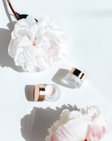 white flower beside pink nail polish