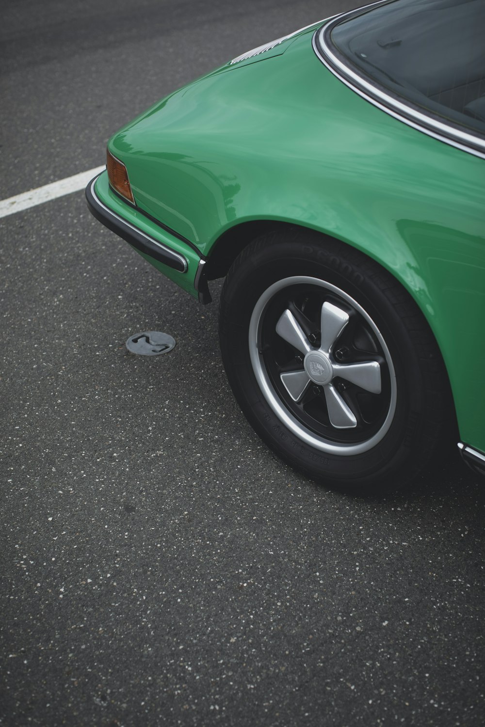 Auto verde sulla strada asfaltata grigia durante il giorno