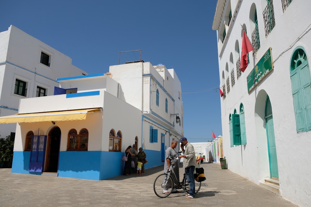 people sitting on bench near white concrete building during daytime