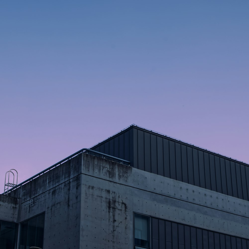 edificio in cemento grigio sotto il cielo blu durante il giorno