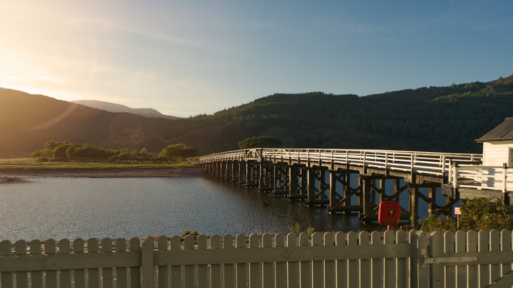 white wooden fence near body of water during daytime