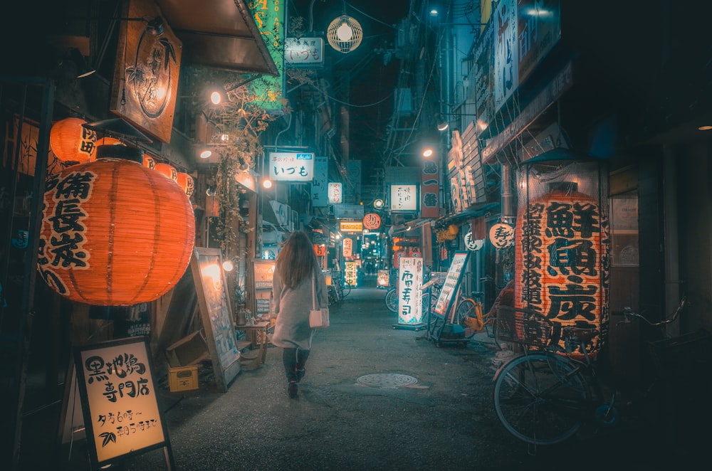 man in white shirt walking on street during nighttime