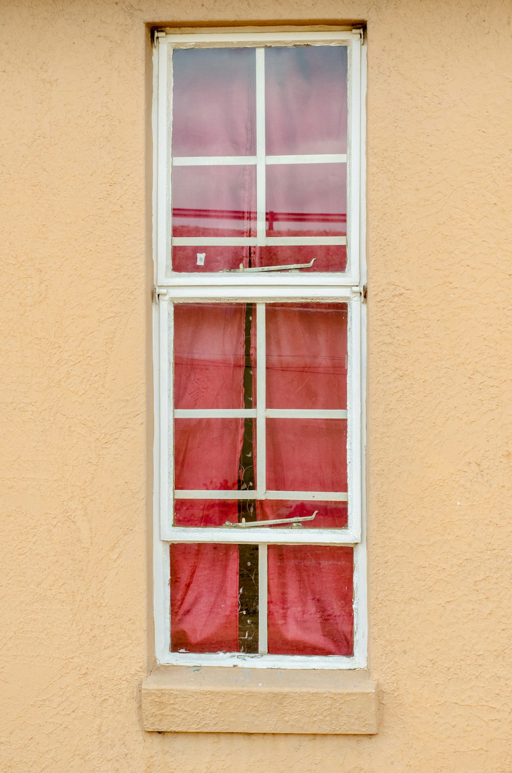 Telaio della finestra in legno rosso su parete in cemento marrone