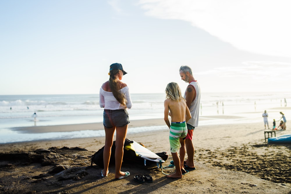 2 women standing on beach during daytime