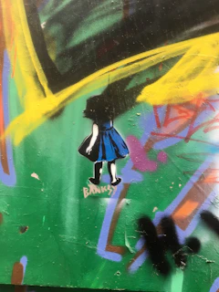 Banksy's iconic image of a policeman frisking a young girl, painted on a city street corner