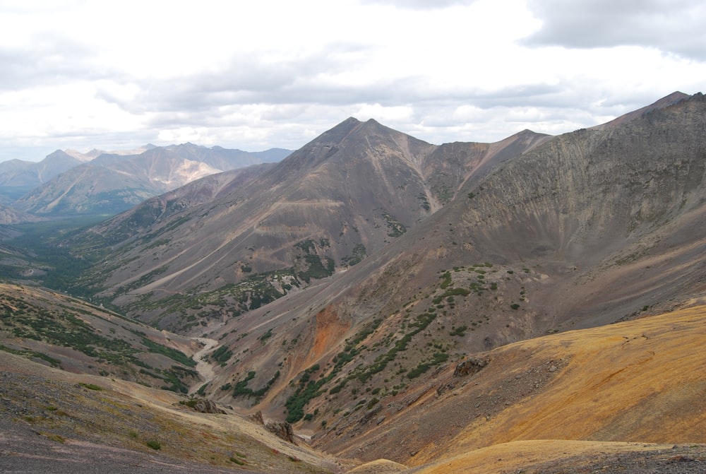 green and brown mountains under white clouds during daytime