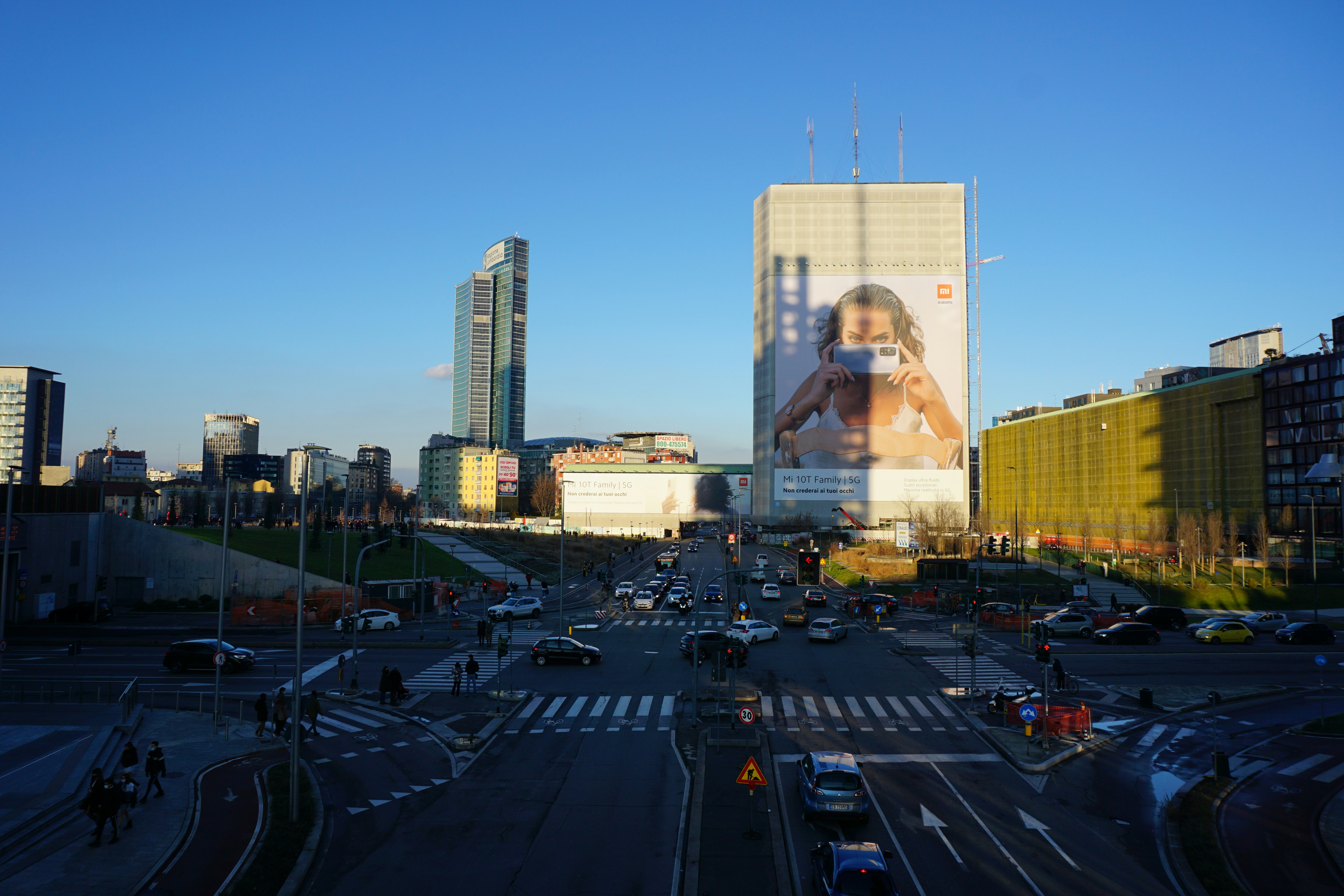 Outdoor hoarding billboard on a city road, daytime, commercial area with traffic