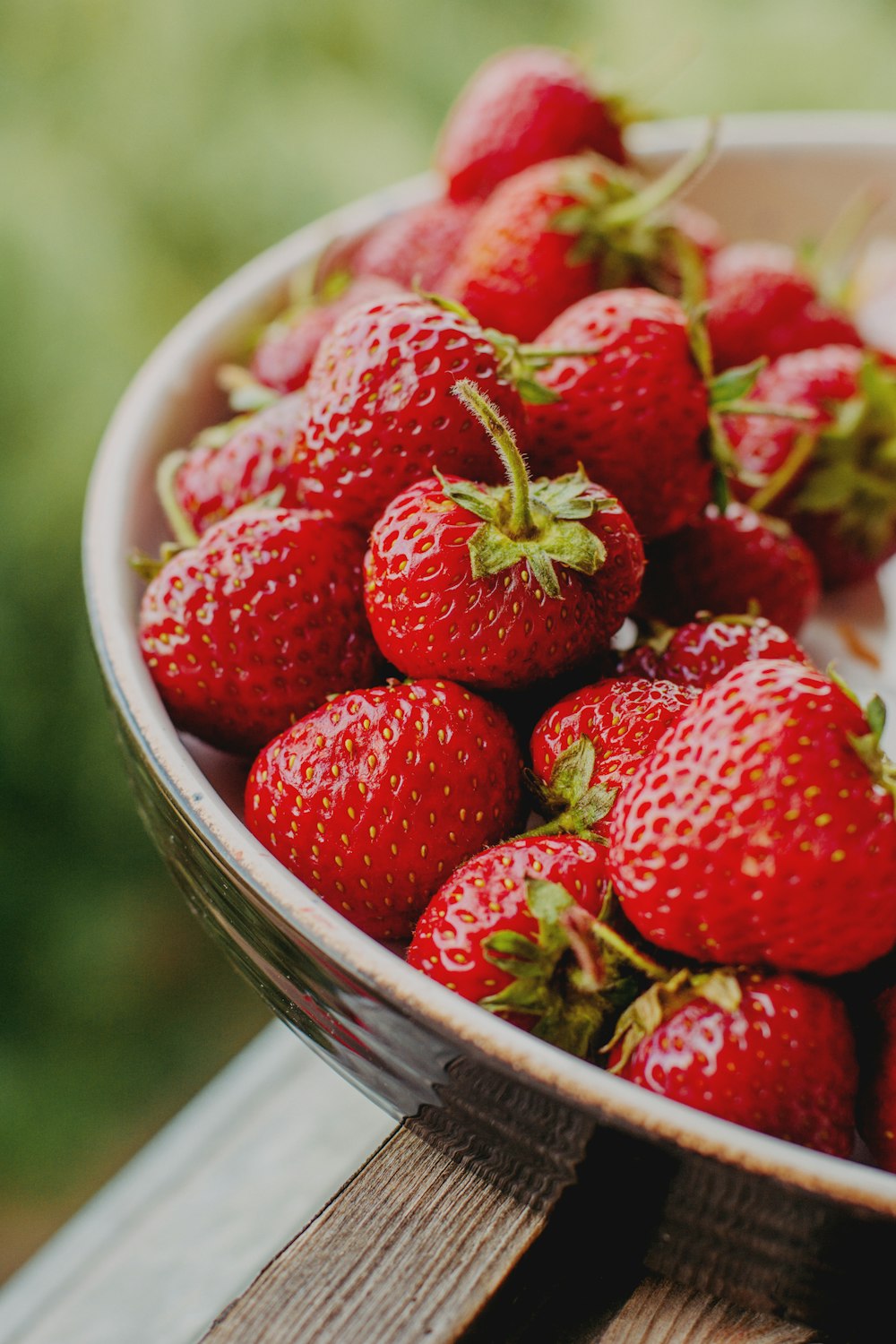 red strawberries in white ceramic bowl