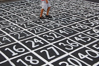 person in white shirt and blue denim shorts standing on black and white floor