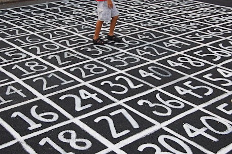 person in white shirt and blue denim shorts standing on black and white floor