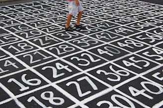 person in white shirt and blue denim shorts standing on black and white floor