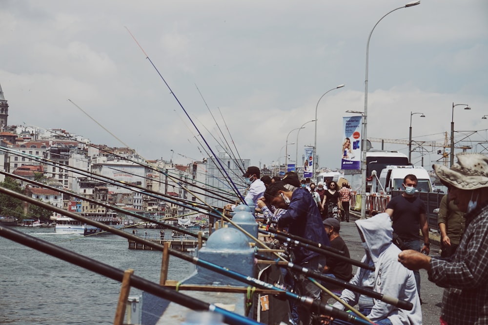 Un grupo de personas de pie en un muelle junto a un cuerpo de agua