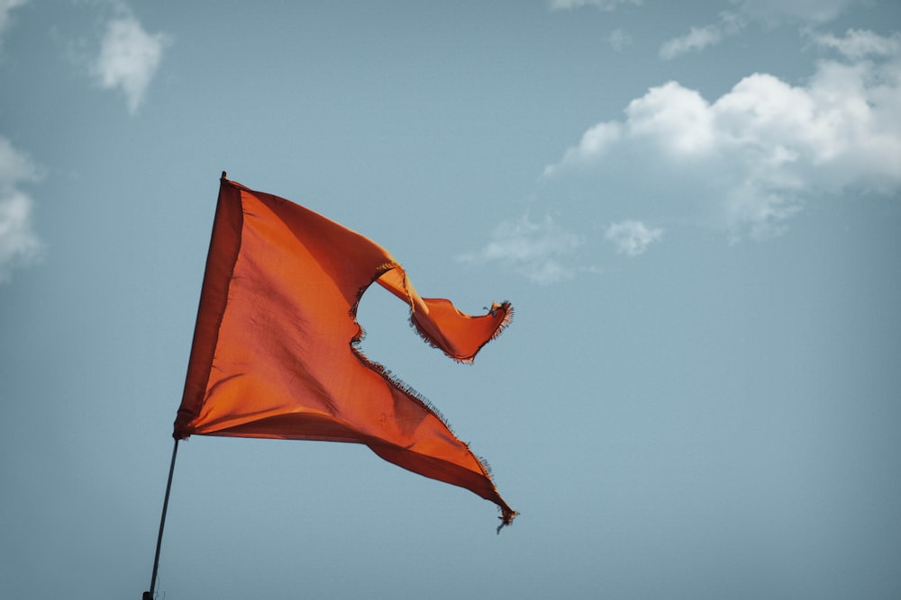 bandeira laranja sob o céu azul durante o dia