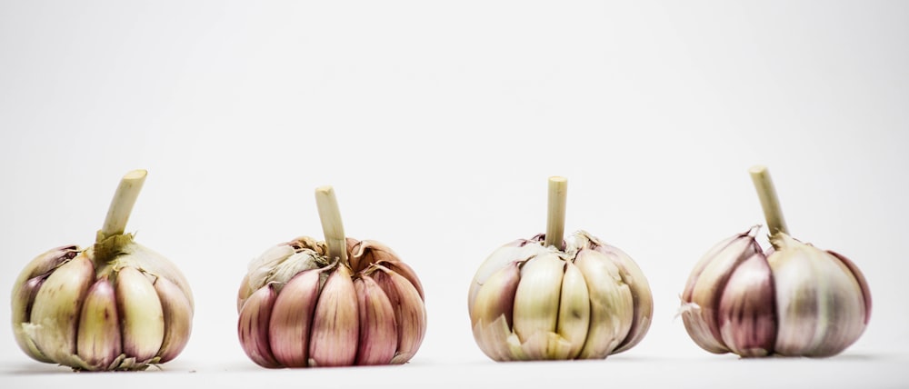 3 brown garlic on white background