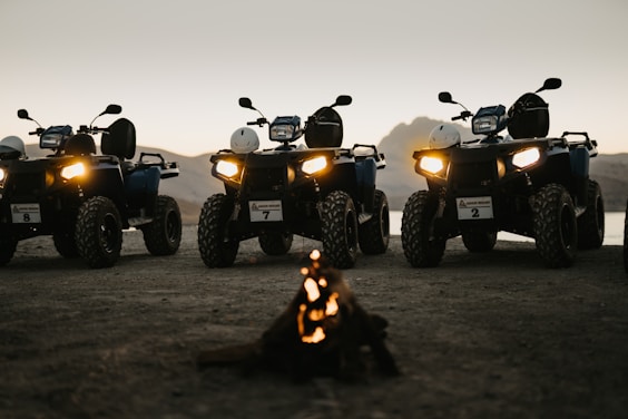silhouette of 2 people riding atv during sunset