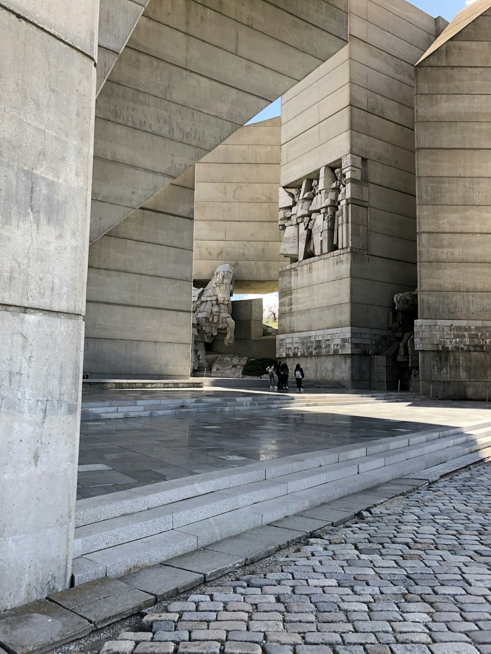 man in black jacket sitting on bench near building