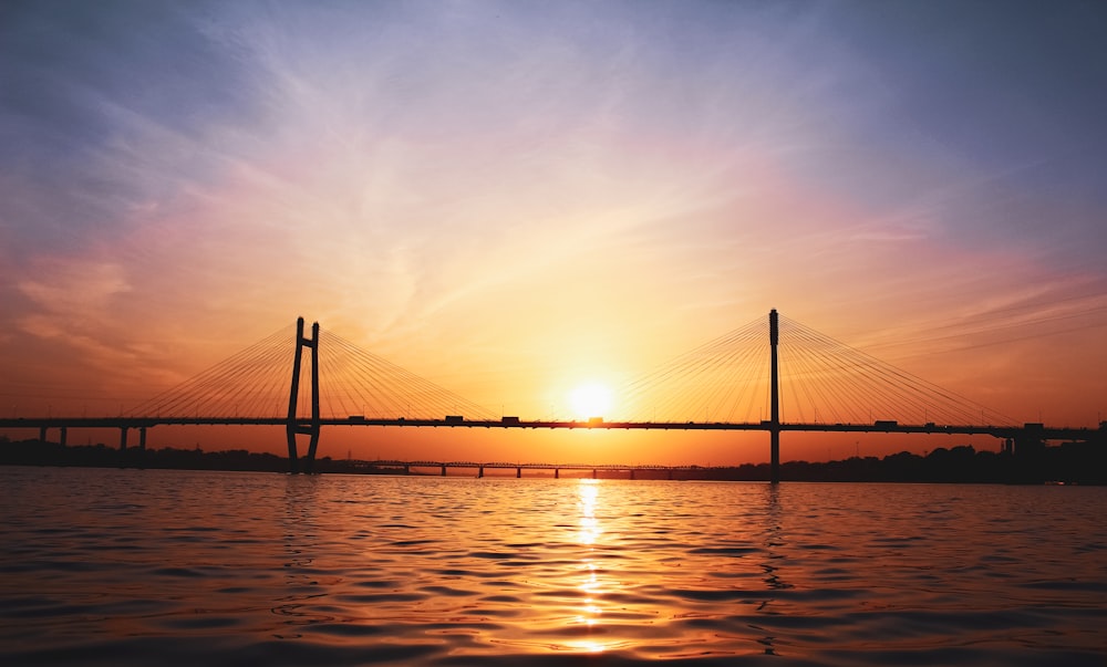Puente sobre el cuerpo de agua durante la puesta del sol