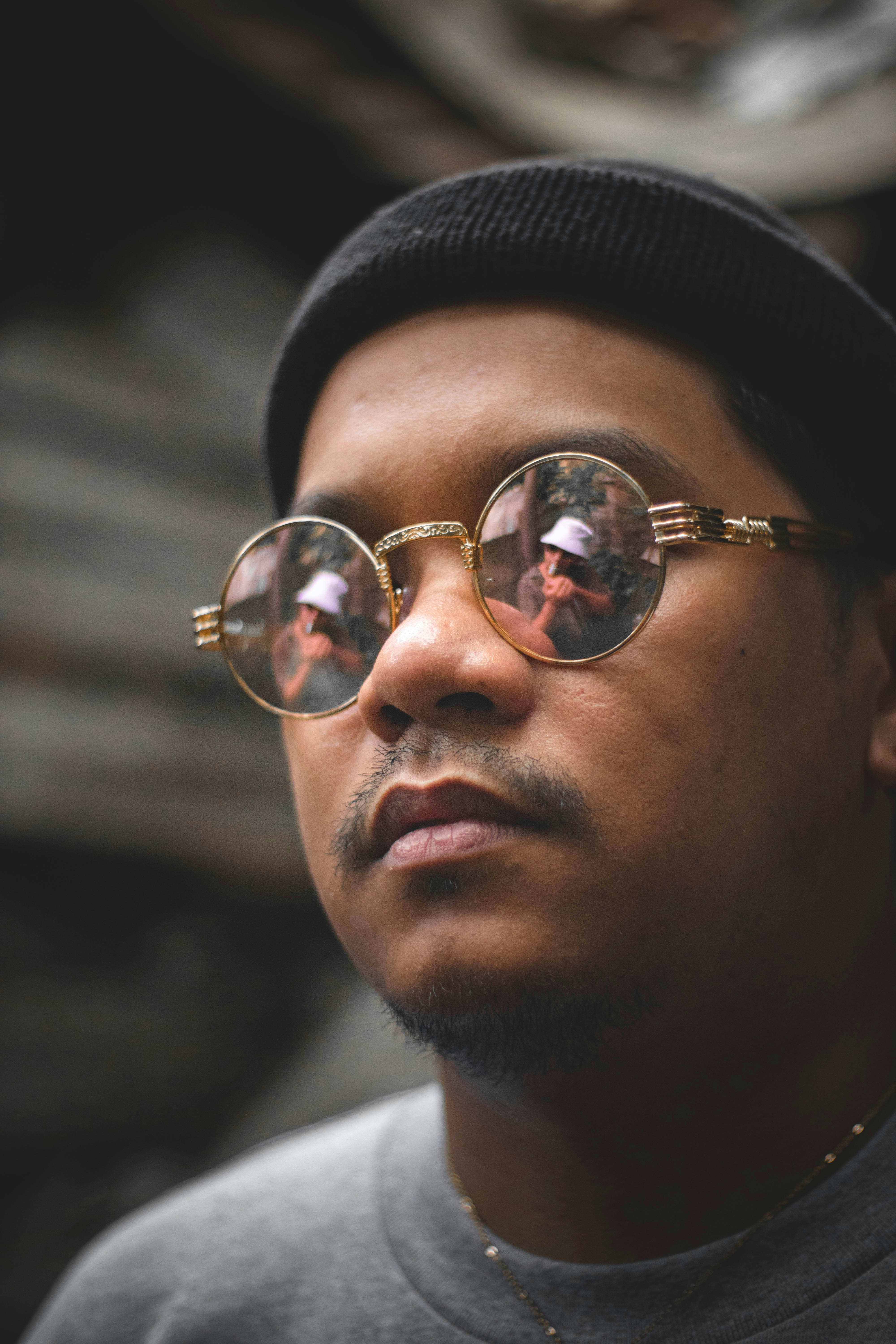 man wearing black knit cap and silver framed aviator sunglasses