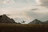 Traveler on horseback crossing the Gobi desert with dramatic clouds overhead.