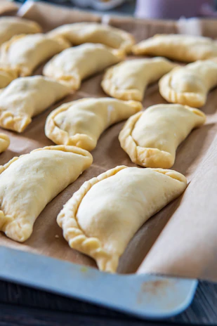 Golden-brown air fryer empanadas arranged neatly on a baking tray