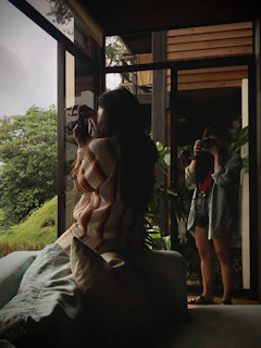 Therapist and client sharing a relaxed moment surrounded by greenery indoors.