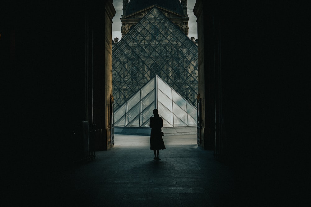 person in black coat walking on hallway