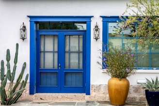 Exterior of a bright blue house with a newly painted front door and trim.