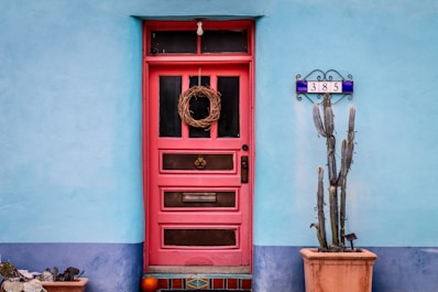 red wooden door with brass door knob