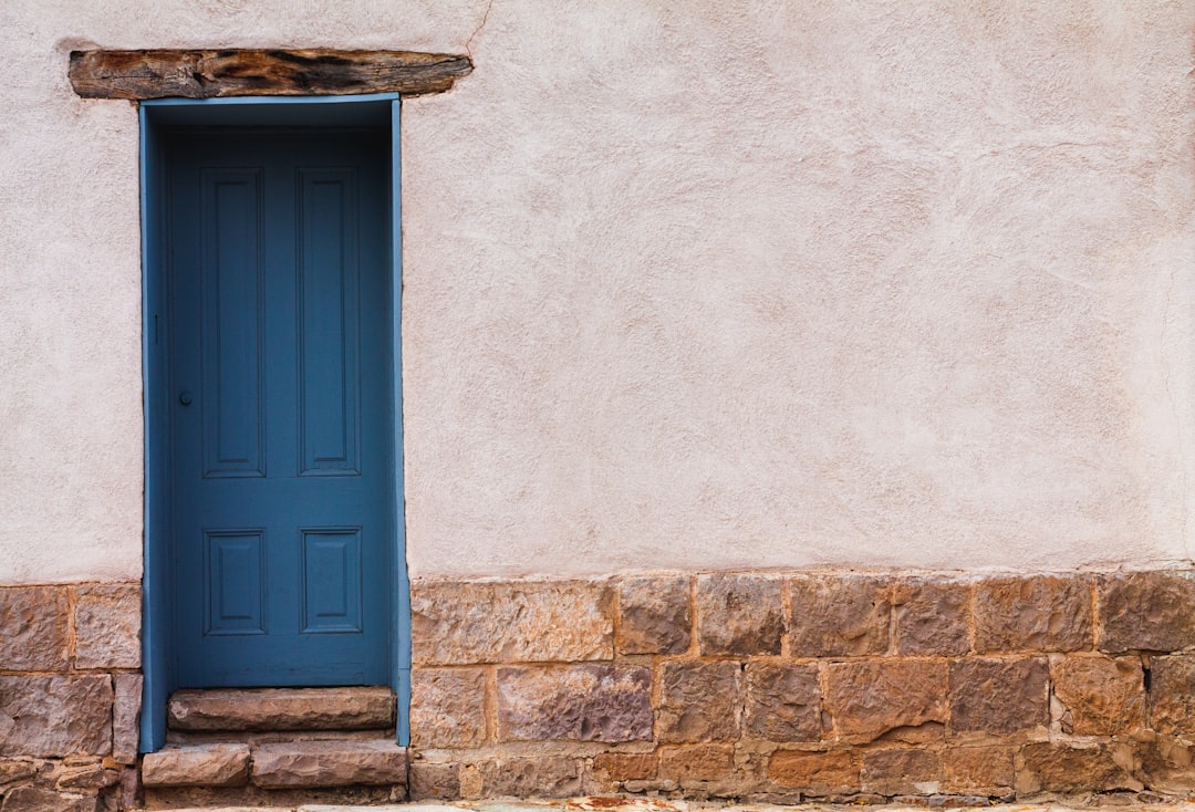 blue wooden door on brown brick wall,