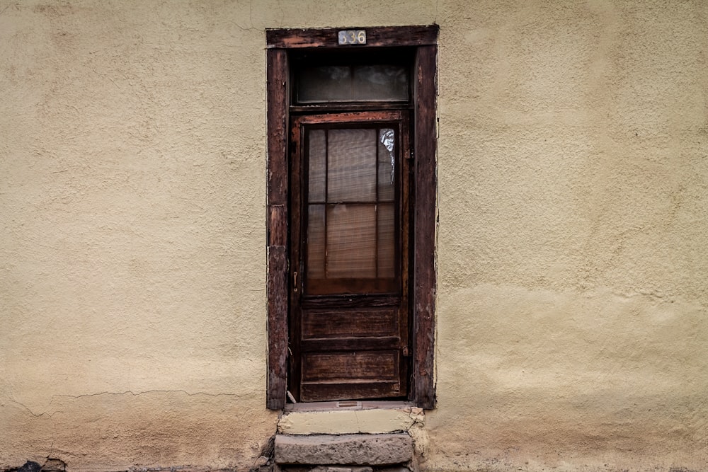 finestra di legno marrone su parete di cemento bianco