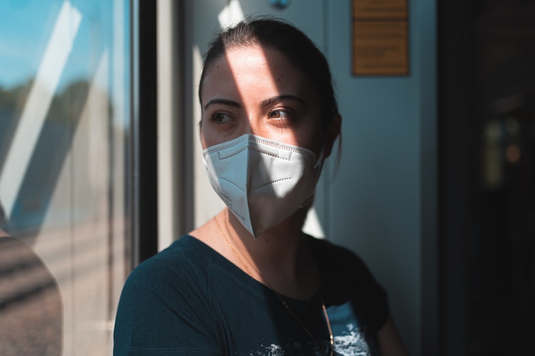 woman in black crew neck shirt wearing white face mask