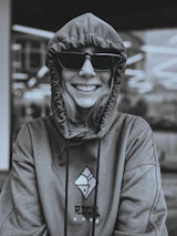 Happy customer wearing a custom printed hoodie from trendora in a sunny urban setting.