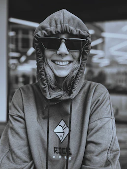 Happy customer wearing a custom printed hoodie from trendora in a sunny urban setting.