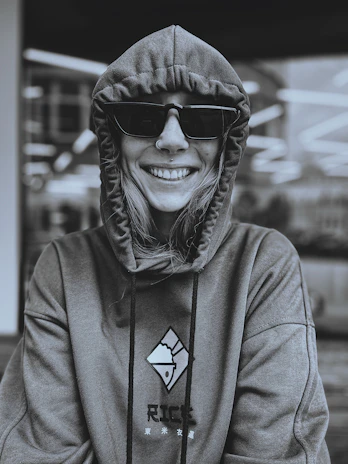 A group photo of the student designers smiling together, wearing their unique hoodie designs.