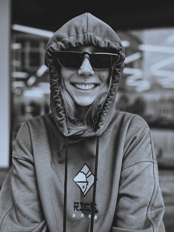 Smiling customer wearing a cozy, custom hoodie from glamafied & more outdoors.