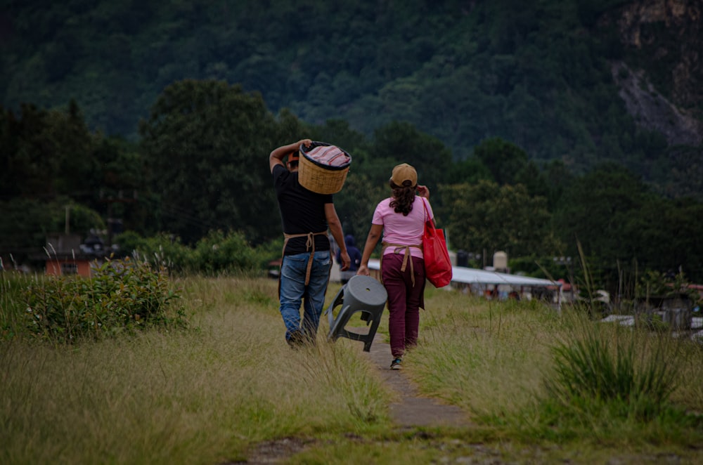 2 women and man standing on green grass field during daytime