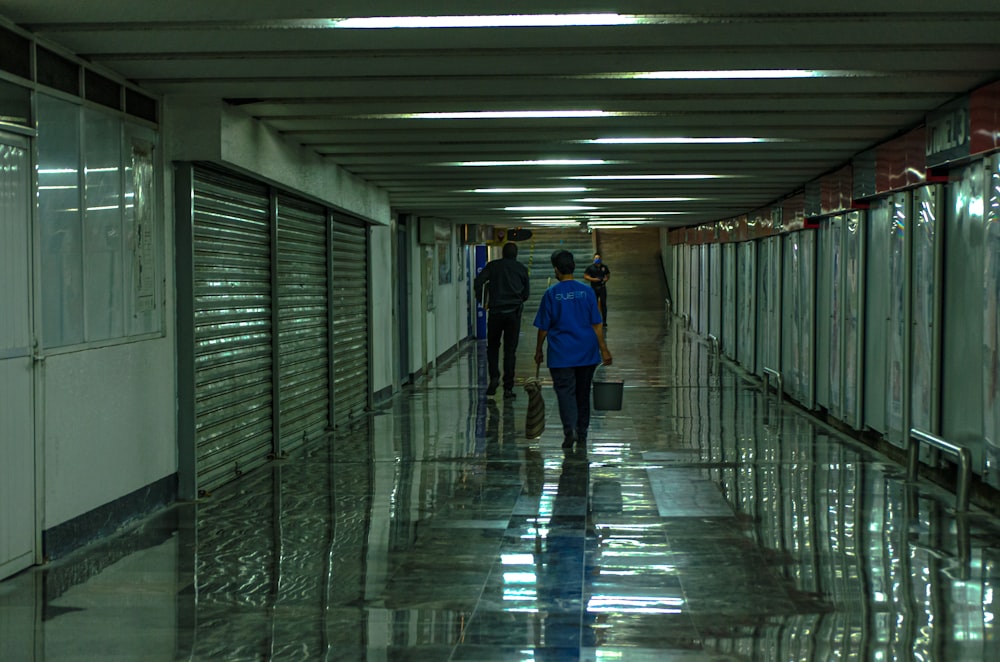 man in blue jacket walking on hallway