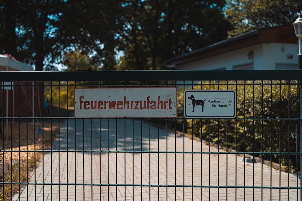 black metal fence with white and red signage