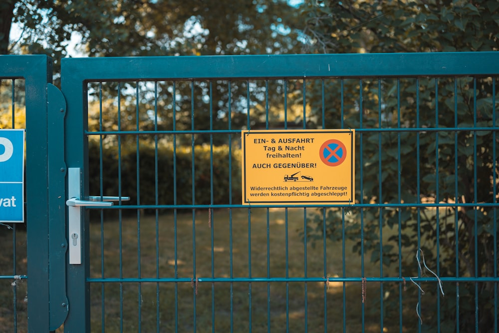 blue metal fence with white and blue signage