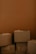 A stack of cardboard boxes against a brown background. The boxes are in various sizes and are closed, some slightly worn, giving a sense of storage or moving.