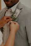 man in gray suit holding white rose