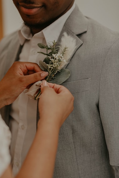 man in gray suit holding white rose