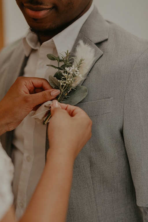 man in gray suit holding white rose