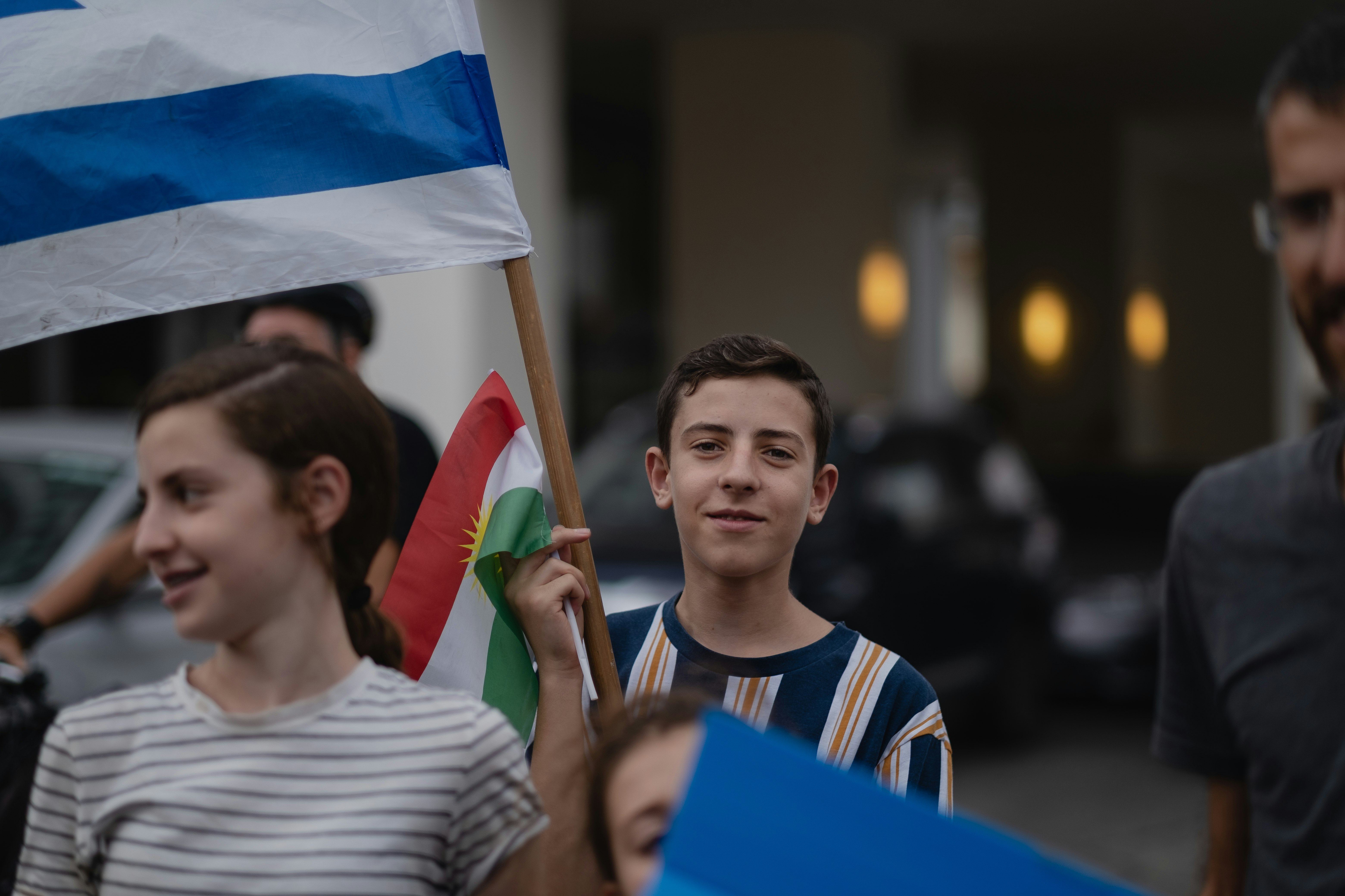 man in white crew neck shirt holding blue flag