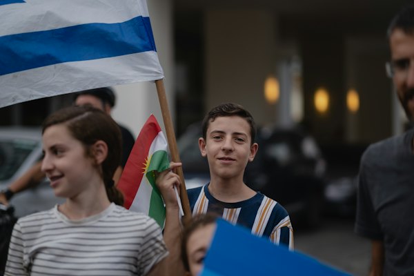 Man in white crew neck shirt holding blue flag — Tel Aviv, Israel