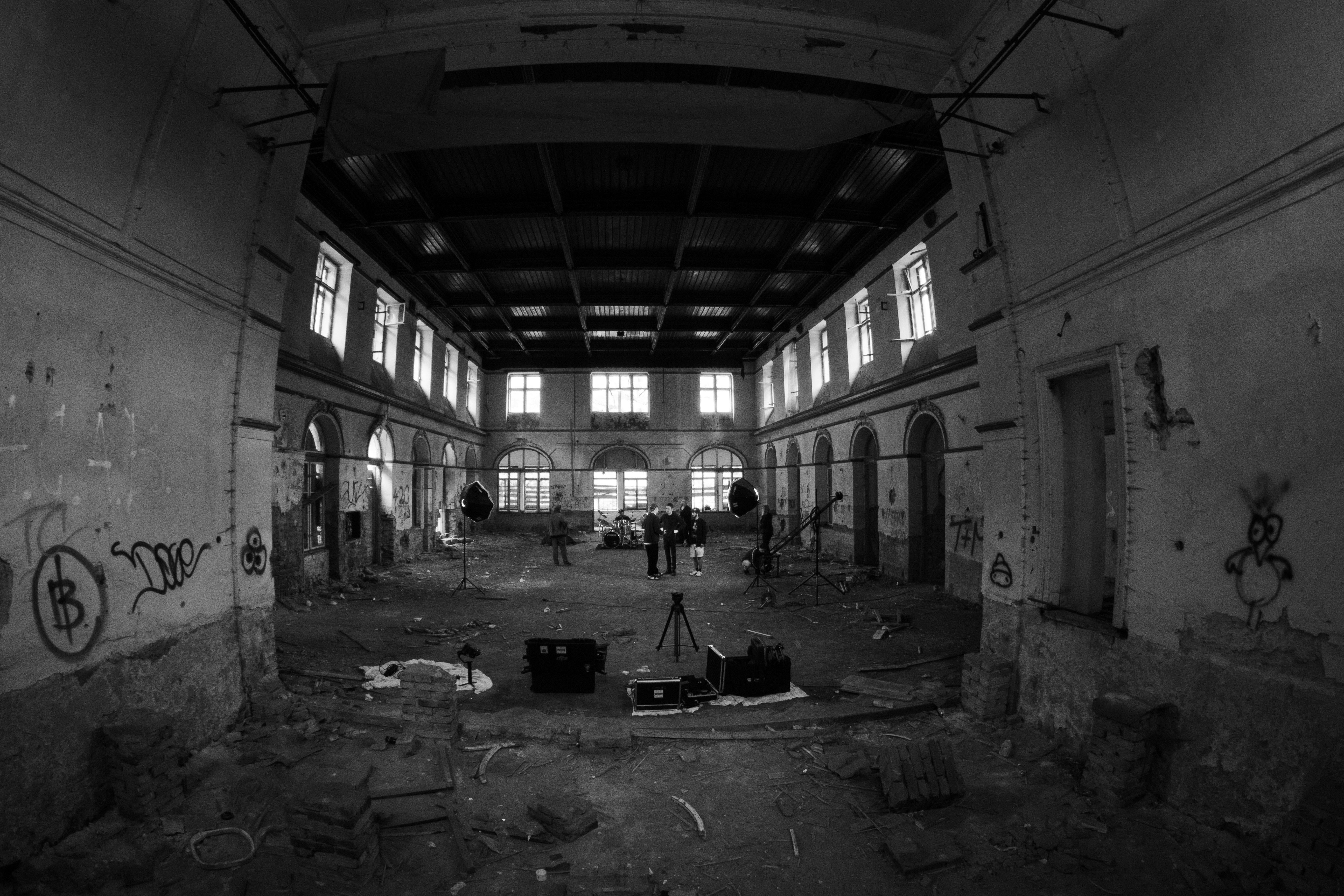 grayscale photo of man sitting on chair inside building