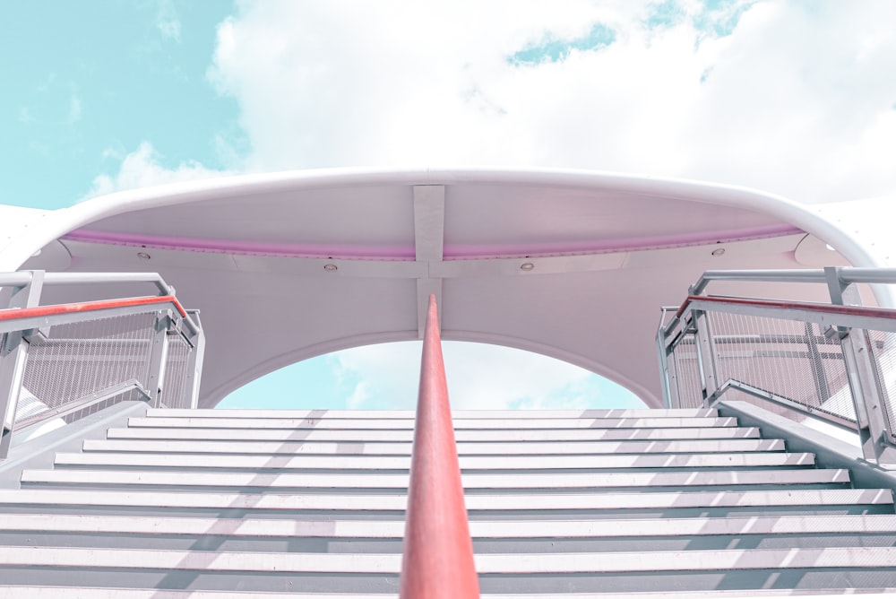 Bâtiment en béton blanc et rouge sous le ciel bleu pendant la journée